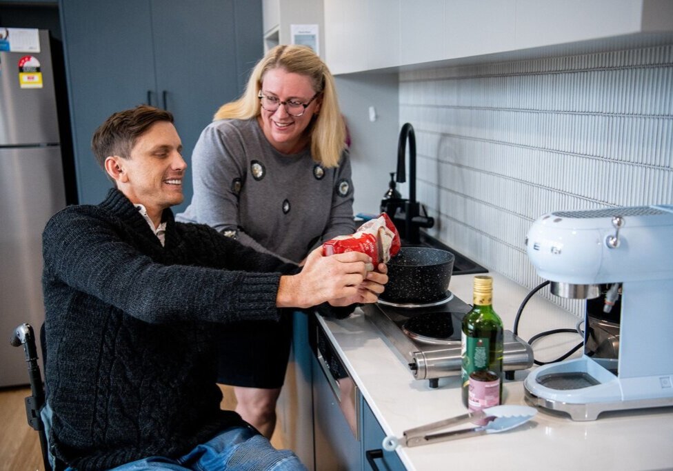 Woman engaging in conversation with a man while actively involved in cooking